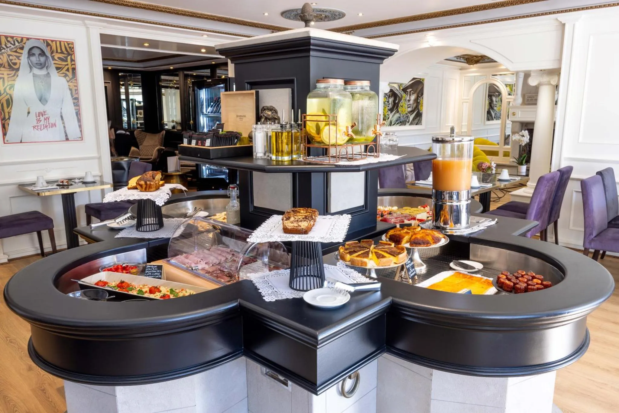 Un buffet propose des pâtisseries, des fruits et des boissons dans une salle lumineuse.