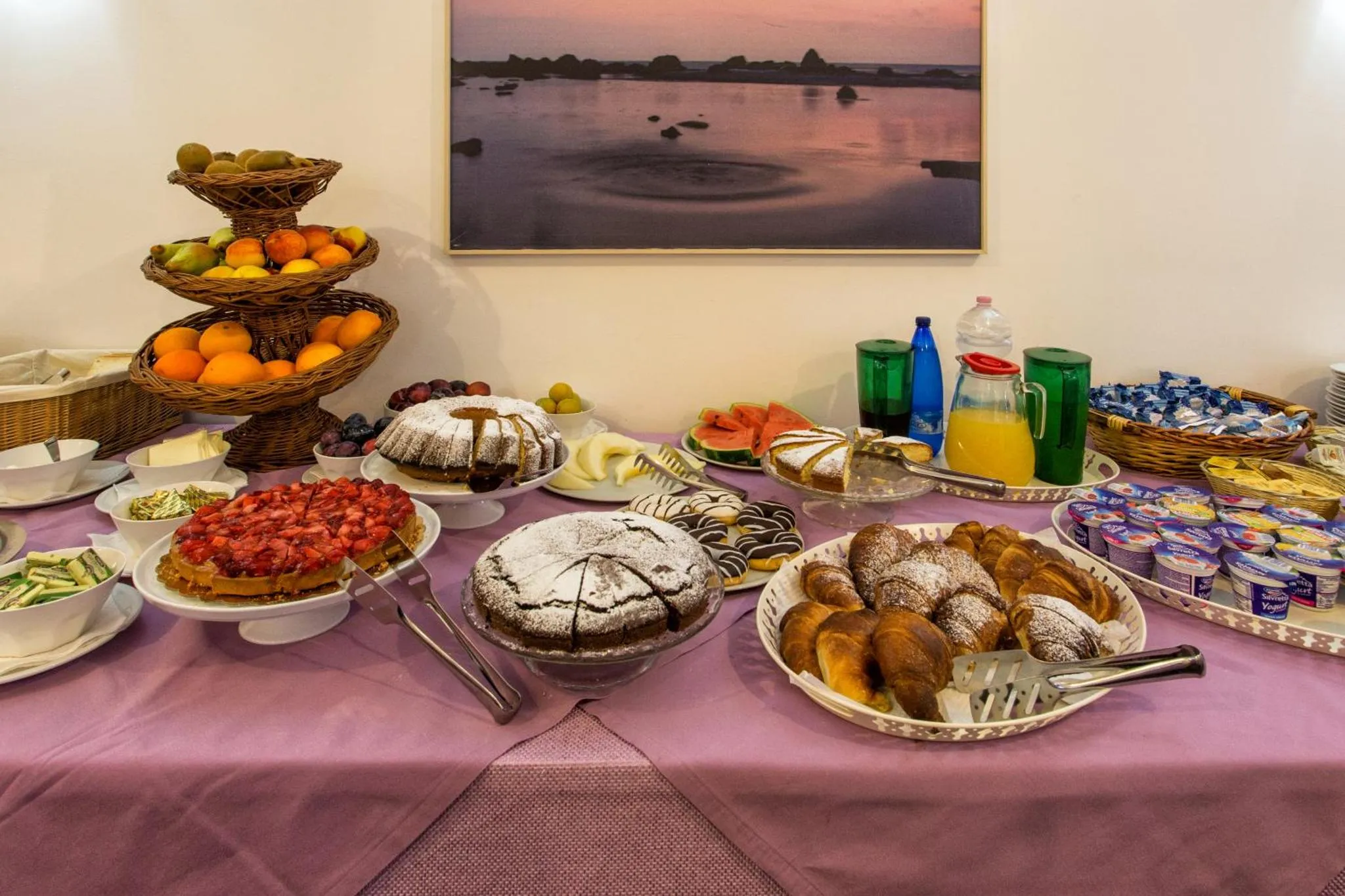 Une table garnie de pâtisseries, de fruits frais et de boissons.