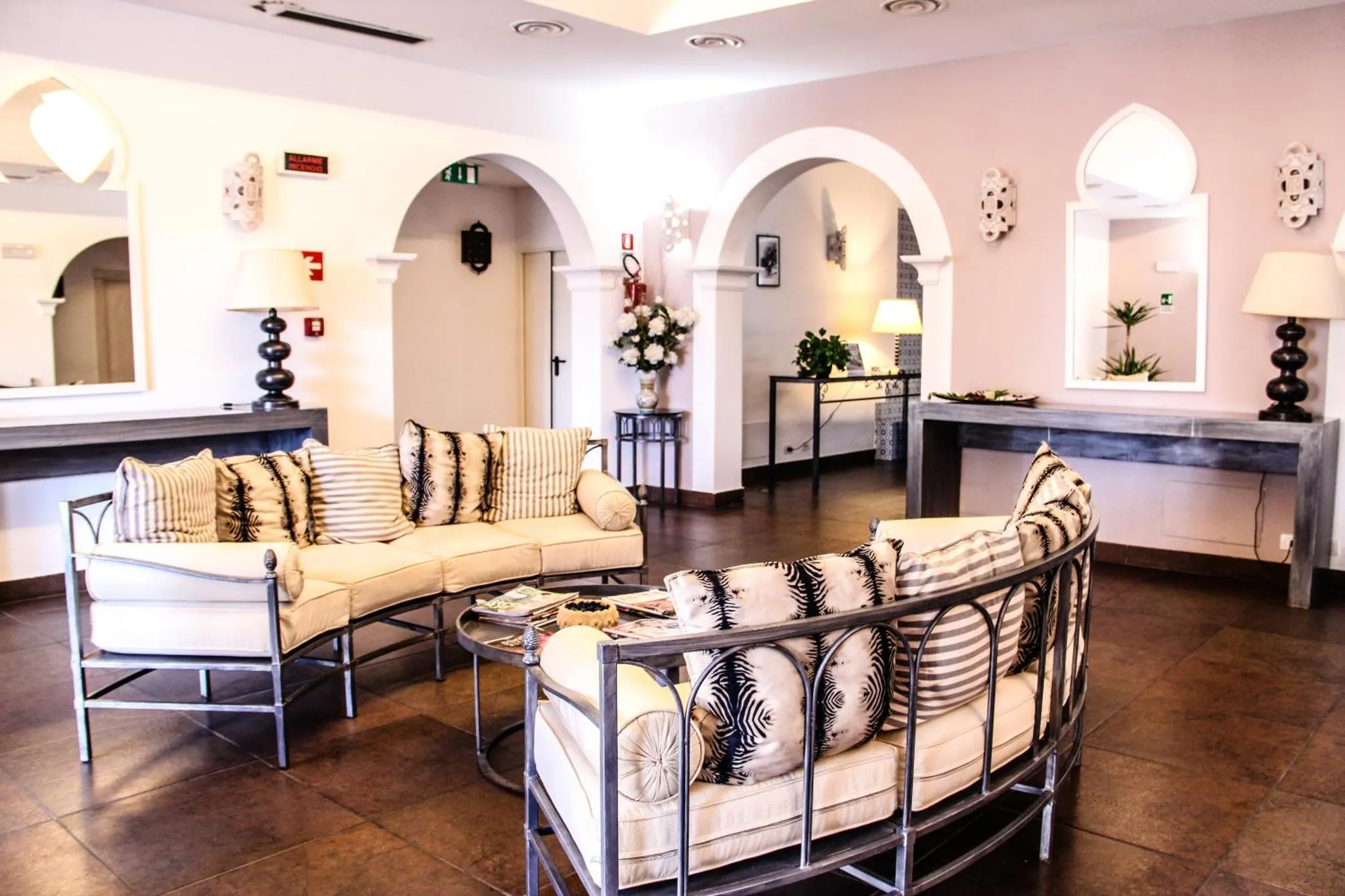 Espace de détente lumineux avec canapés et décoration murale.
