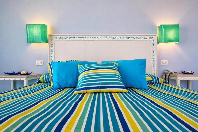 Un lit coloré avec des oreillers décoratifs dans une chambre.