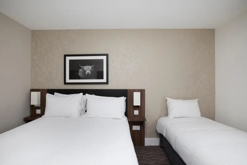 Une chambre avec deux lits simples et une décoration murale.