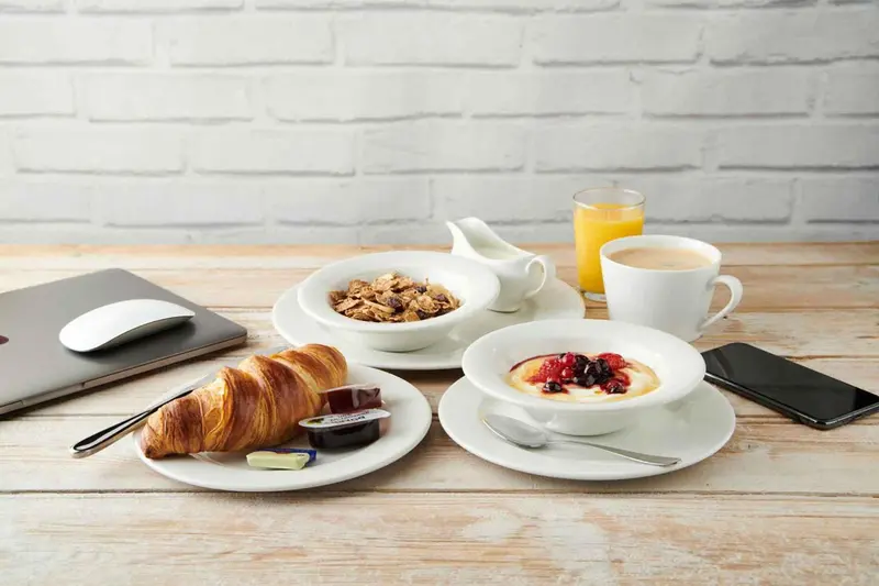 Un petit-déjeuner est présenté sur une table en bois clair.