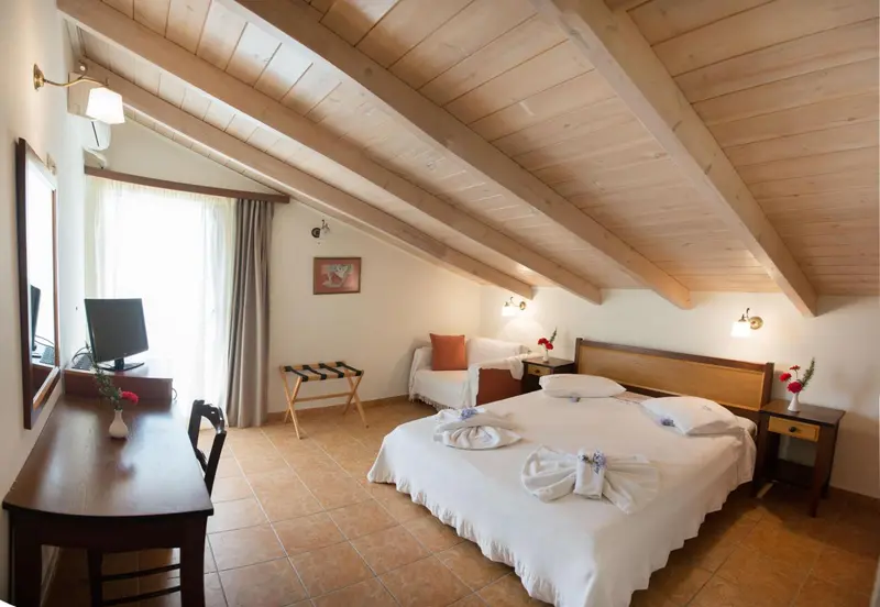 Une chambre lumineuse avec un lit double et un bureau en bois.