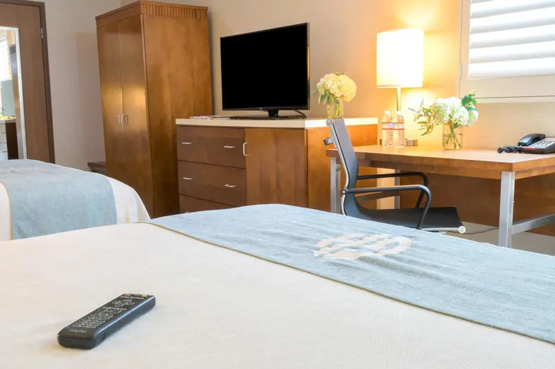 Une chambre d'hôtel lumineuse avec un lit, un bureau et une télévision.