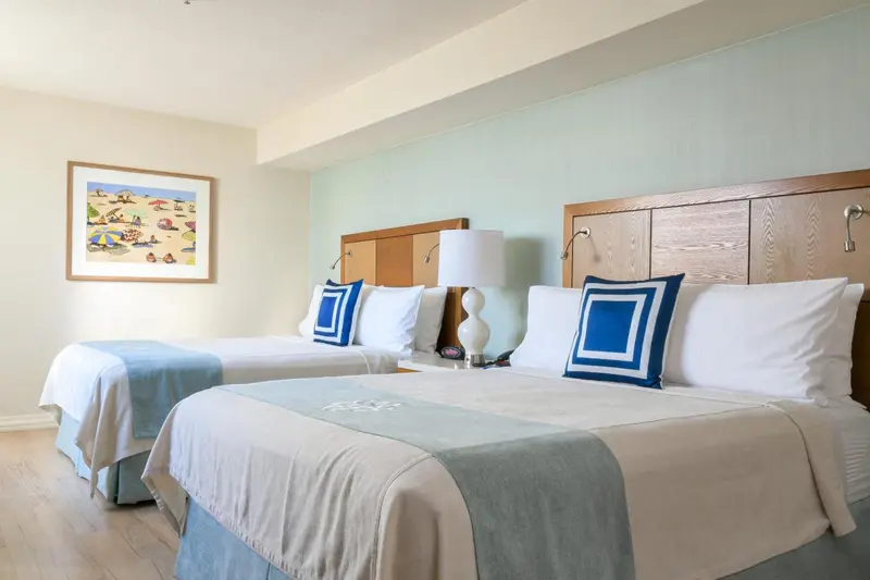 Une chambre lumineuse avec deux lits simples et une décoration sobre.