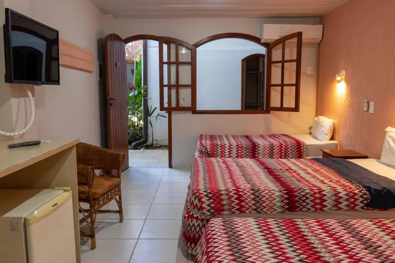 Une chambre lumineuse avec deux lits simples et une vue sur une cour intérieure.