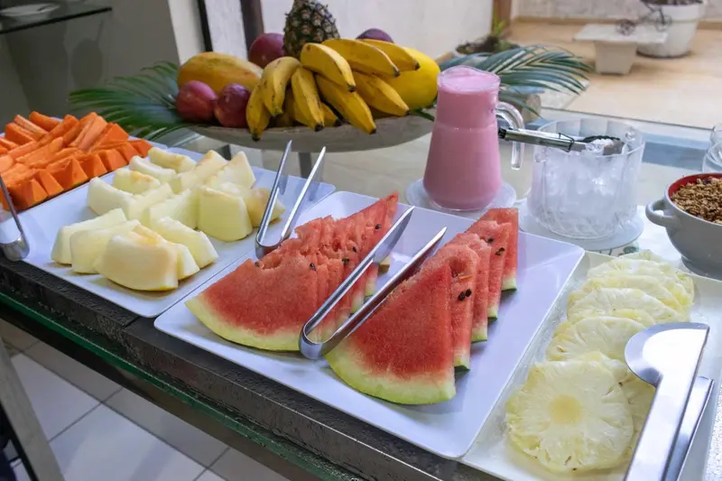 Une table garnie de fruits frais et d'une boisson rose.