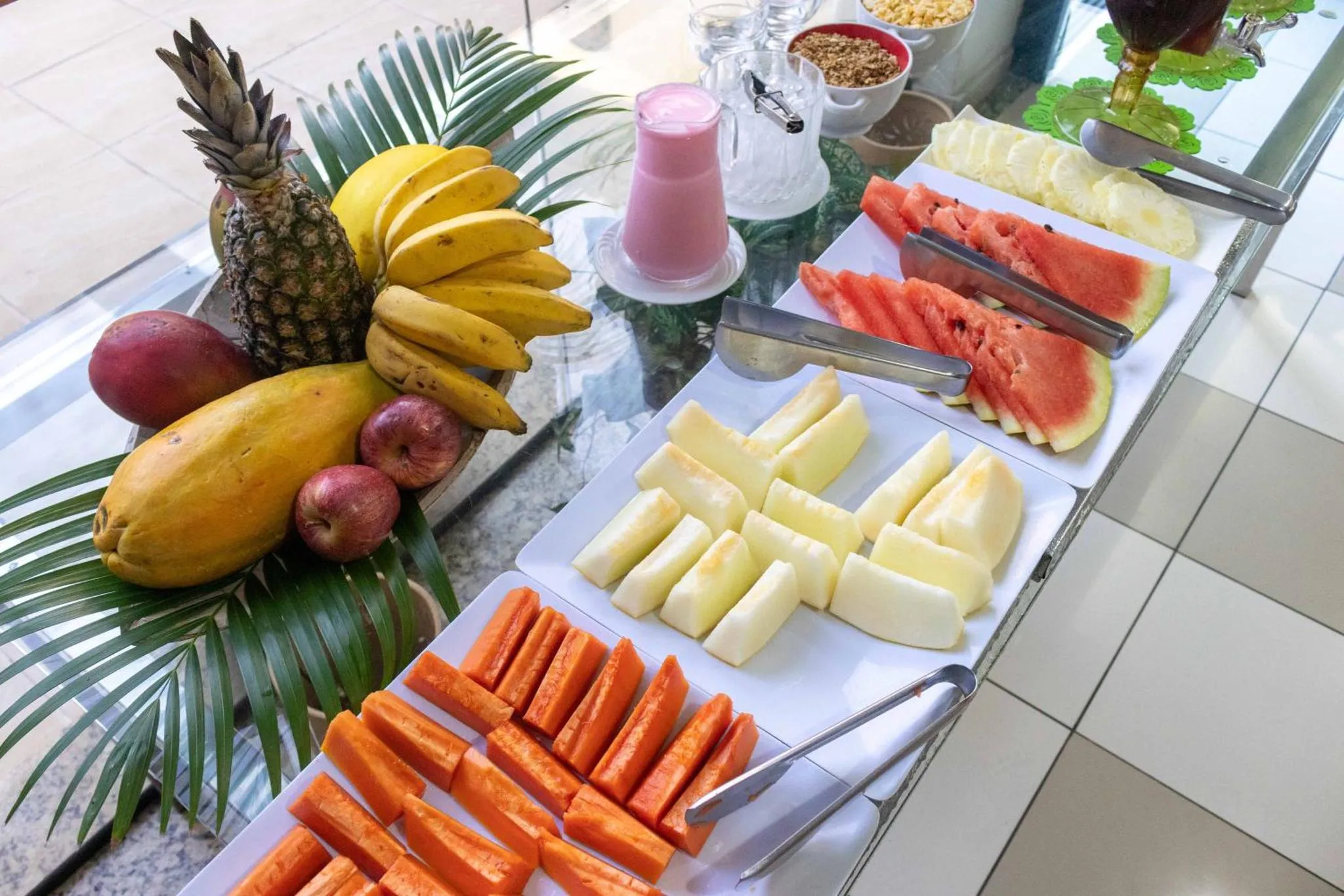 Présentation de fruits frais et de jus sur un buffet.