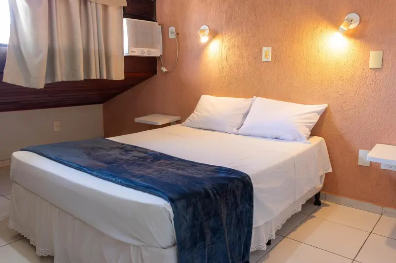 Une chambre avec un lit double et des lampes murales.