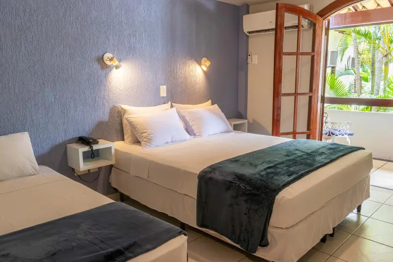 Une chambre lumineuse avec un lit double et une table de chevet.