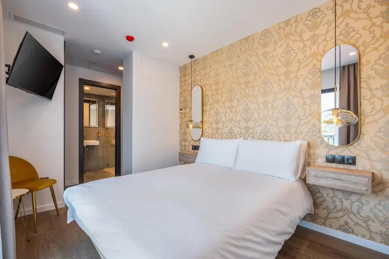 Une chambre lumineuse avec un grand lit et un mur décoratif.