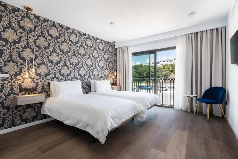Une chambre lumineuse avec un grand lit et un balcon.