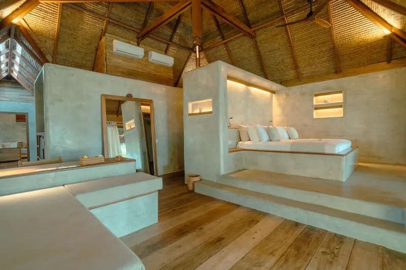 Intérieur d'une chambre avec un lit intégré dans une structure en béton.