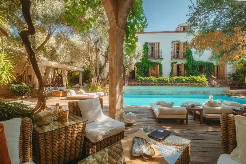 Terrasse aménagée avec des transats et des tables basses près d'une piscine.