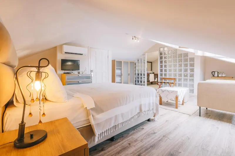 Une chambre lumineuse avec un grand lit et un coin salon.