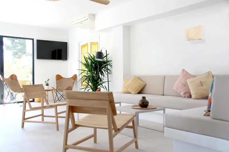 Espace de détente intérieur avec canapés et fauteuils en bois clair.