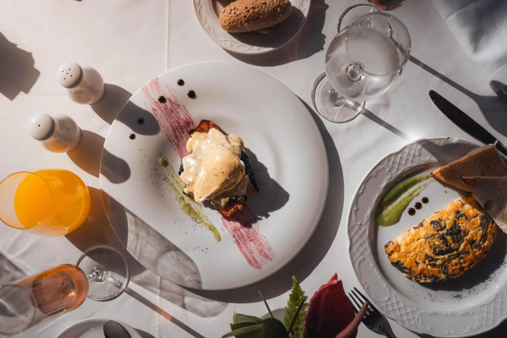 Assiettes de plats décorés sur une table nappée en lin.