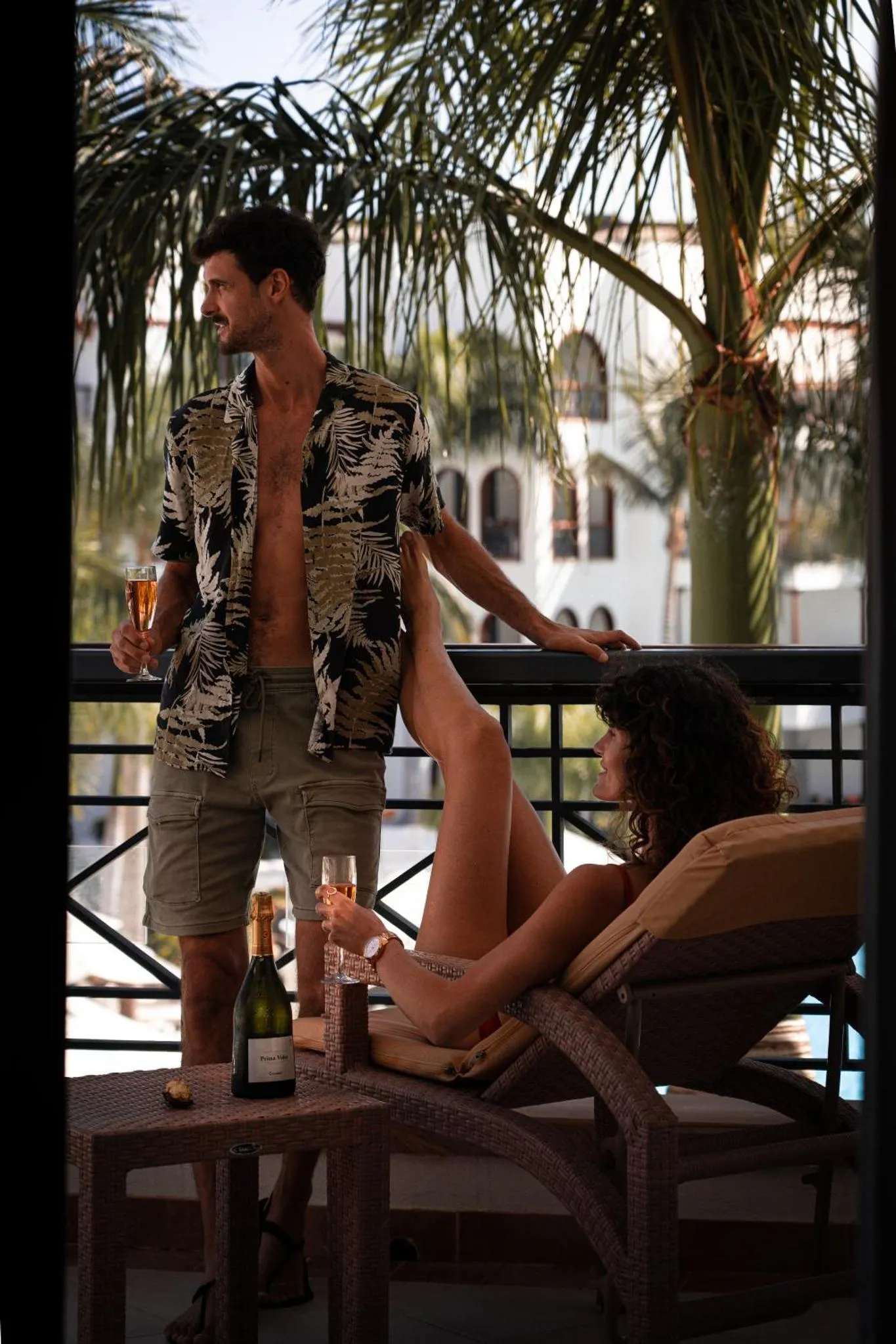 Un couple se détend sur une terrasse avec des boissons.