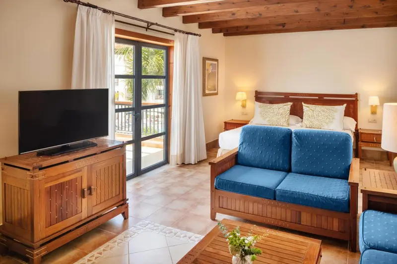 Une chambre lumineuse avec un canapé et un accès à un balcon.