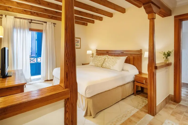 Une chambre lumineuse avec un lit à baldaquin en bois.