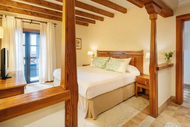 Une chambre lumineuse avec un lit à baldaquin en bois.