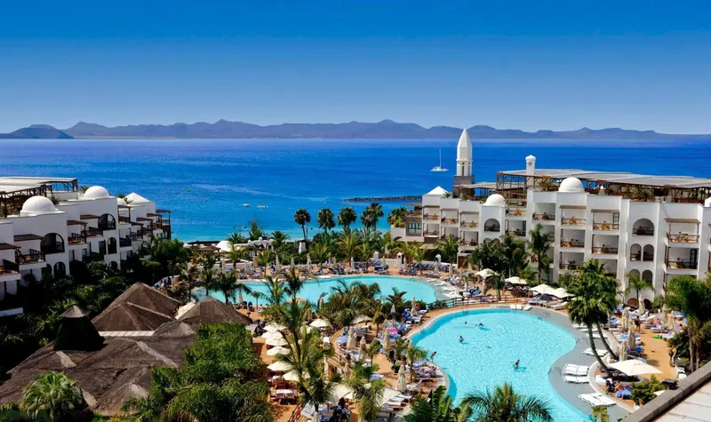 Vue aérienne d'un complexe hôtelier avec piscine et accès à la mer.