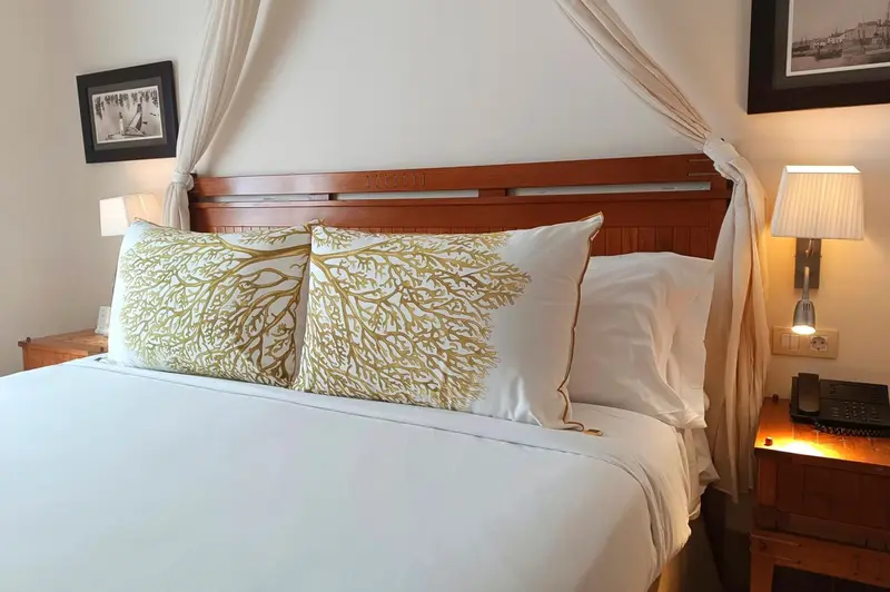 Un lit double avec une tête de lit en bois et des oreillers décorés.