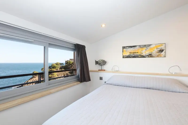 Une chambre lumineuse avec un grand lit donnant sur la mer.