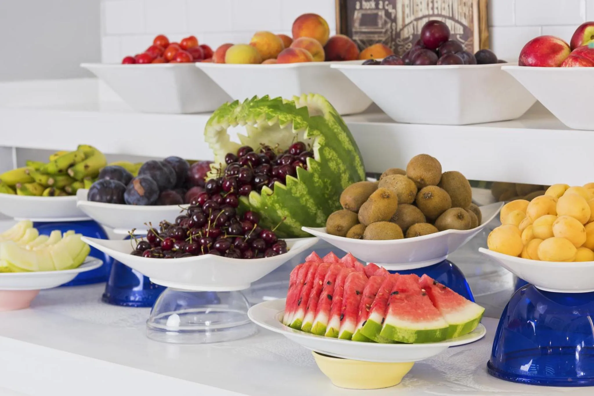 Une variété de fruits frais est présentée sur un buffet blanc.