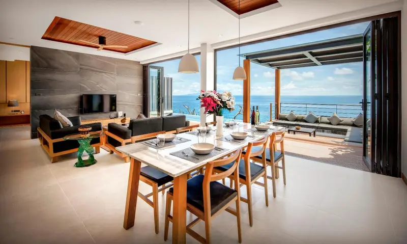 Espace de vie lumineux avec coin repas et vue sur la mer.