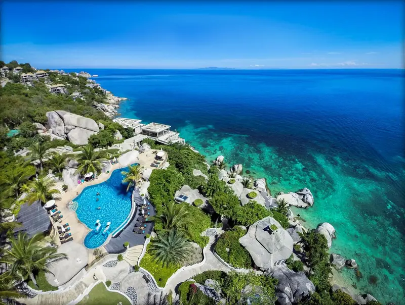 Vue aérienne d'un complexe hôtelier avec piscine et accès à la mer.