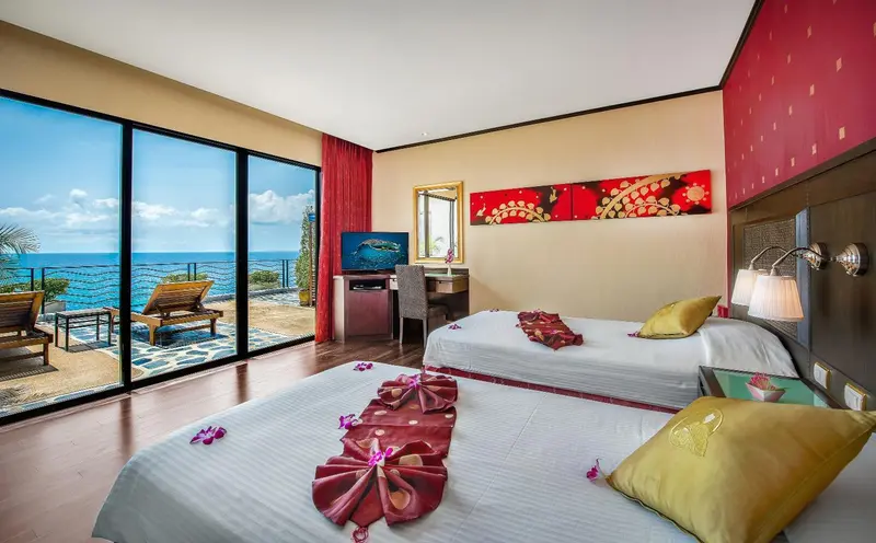 Chambre lumineuse avec vue sur la mer et balcon aménagé.