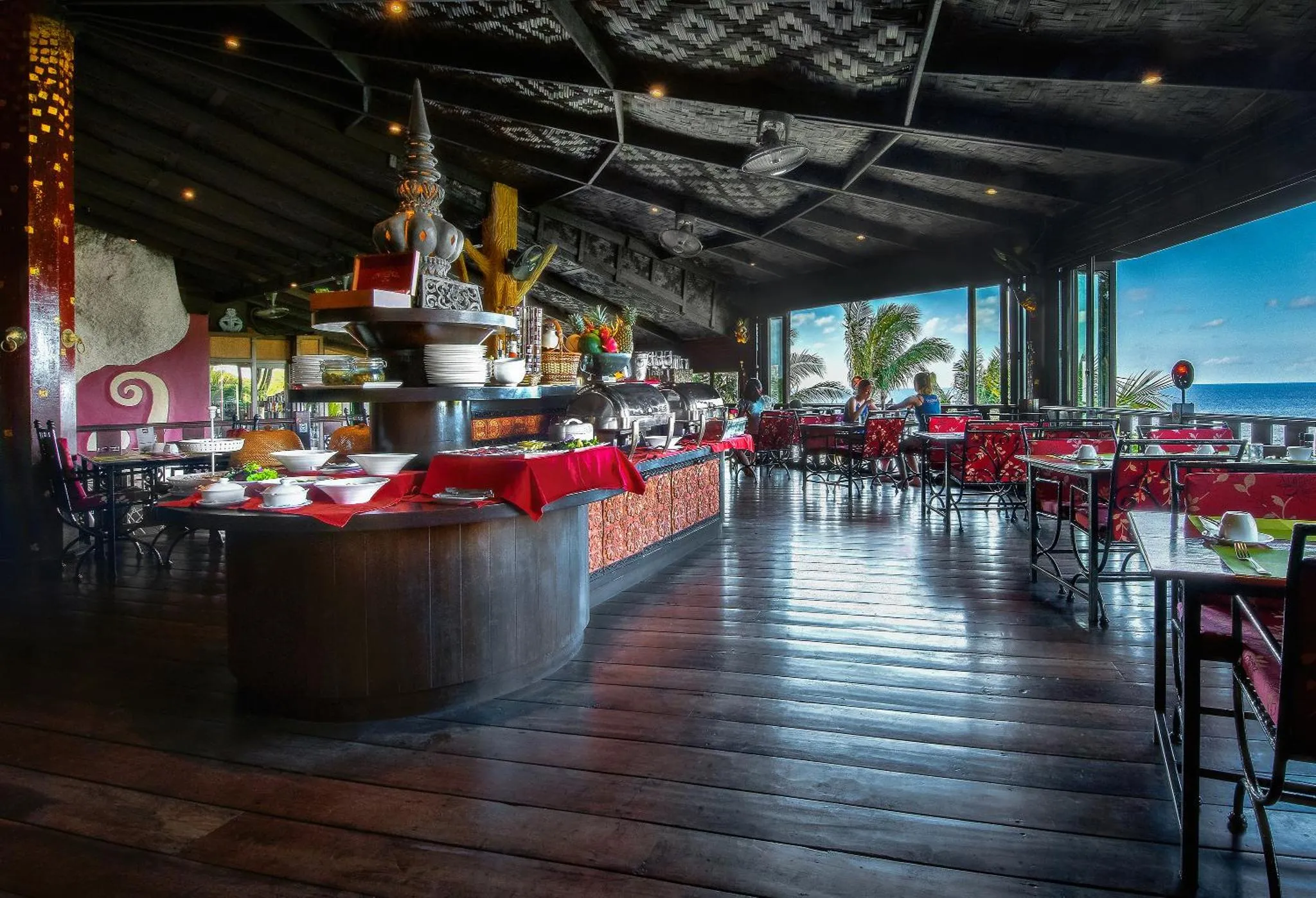 Une salle de restaurant spacieuse avec un buffet et une vue sur la mer.