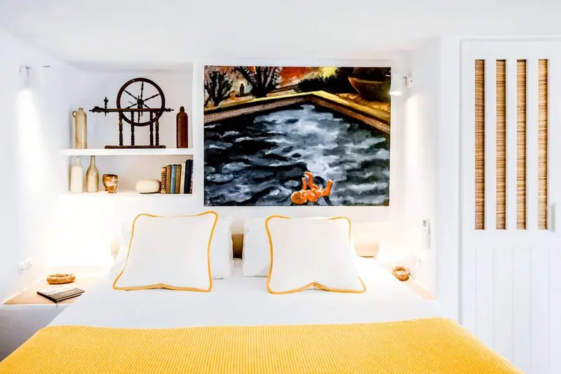 Une chambre lumineuse avec un grand tableau abstrait au-dessus du lit.