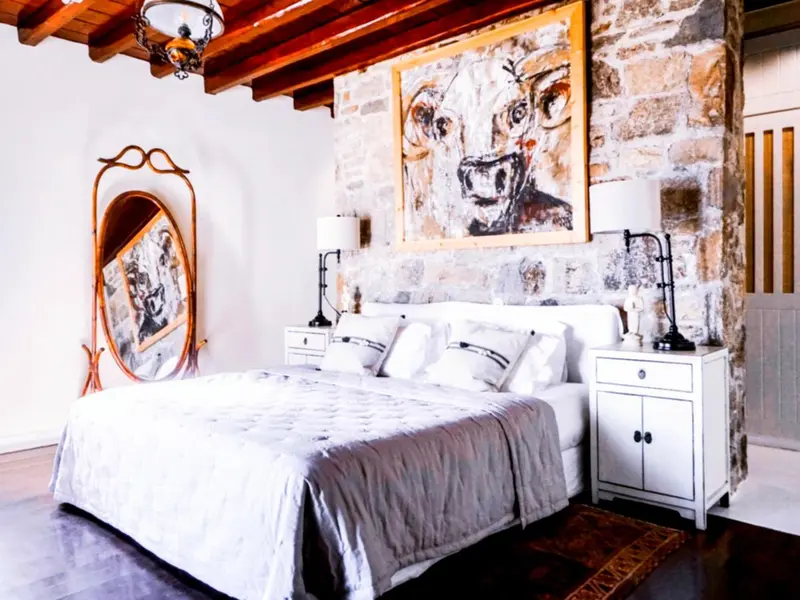 Une chambre lumineuse avec un grand lit et une décoration murale originale.