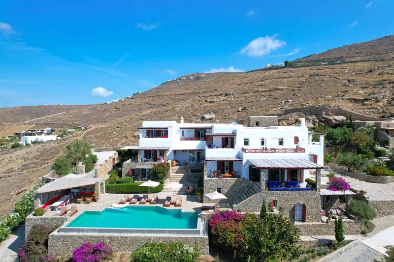 Vue aérienne d'un bâtiment blanc avec une piscine et des transats.