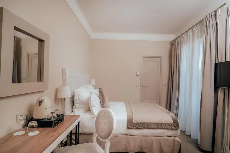 Une chambre lumineuse avec un lit double et un bureau.