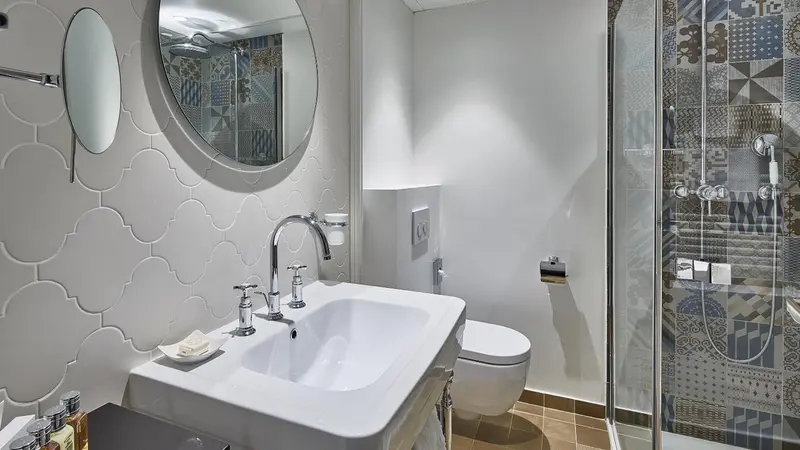 Une salle de bain moderne avec des carreaux décoratifs et une douche vitrée.