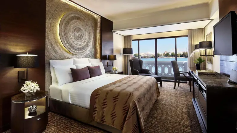 Une chambre avec un grand lit et une vue sur un paysage urbain.