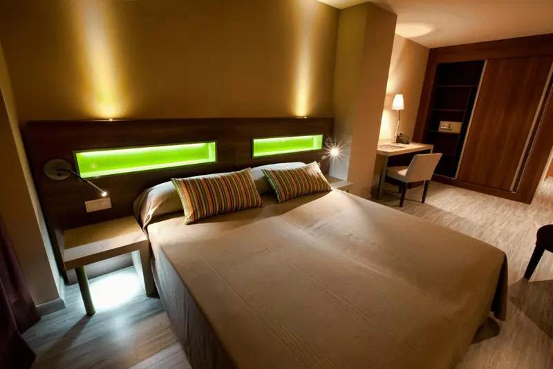 Une chambre moderne avec un grand lit et un éclairage d'ambiance.