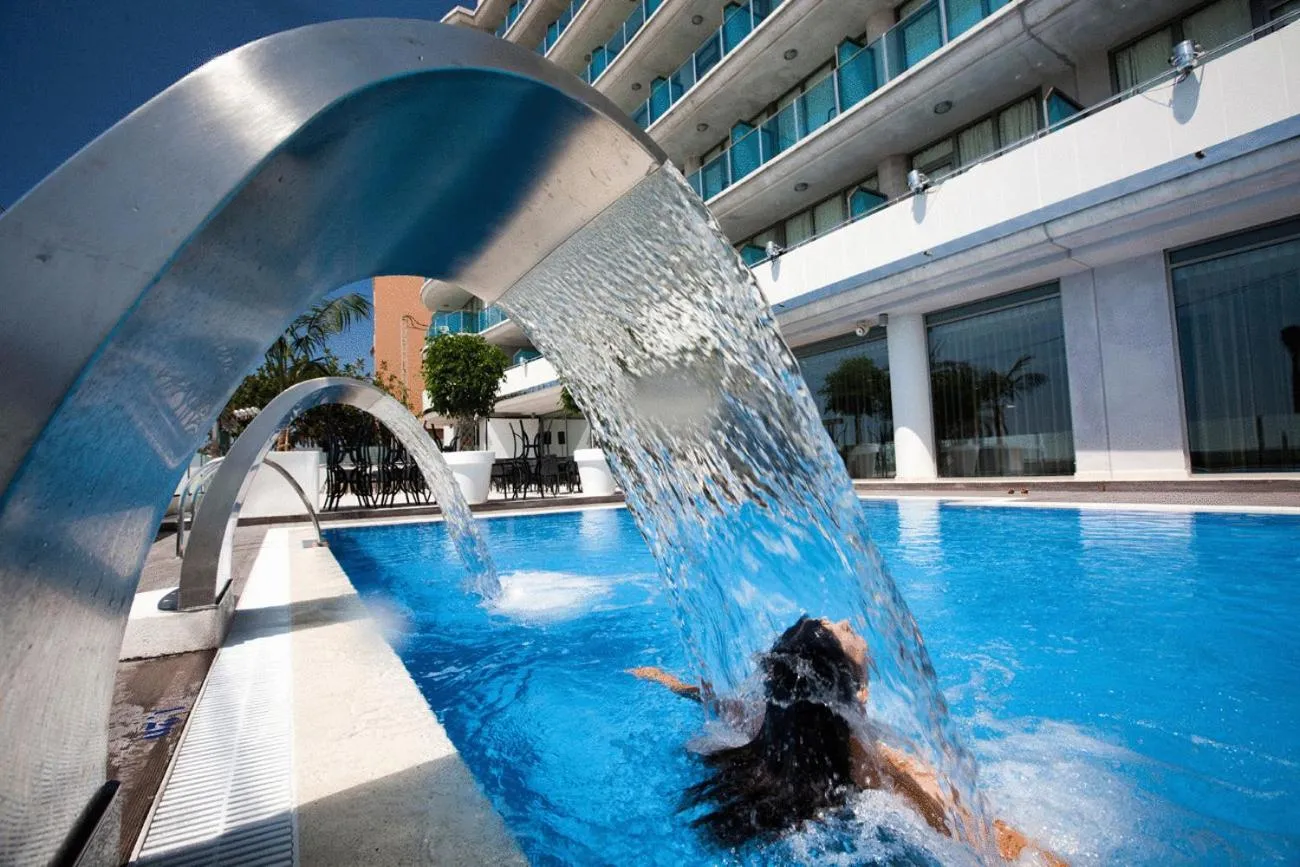 Une personne se détend dans une piscine avec une cascade d'eau.