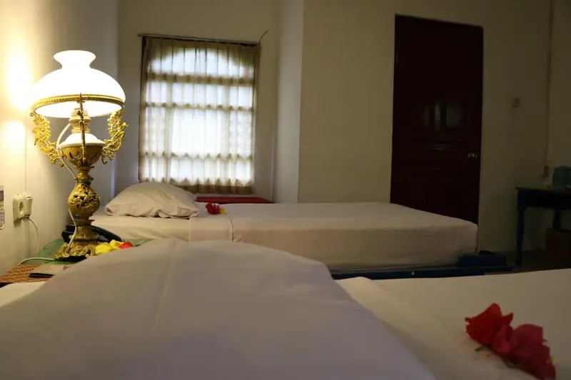 Une chambre lumineuse avec deux lits simples et une décoration florale.