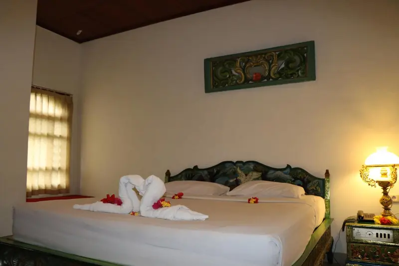 Une chambre lumineuse avec un lit décoré de serviettes en forme de cygnes.