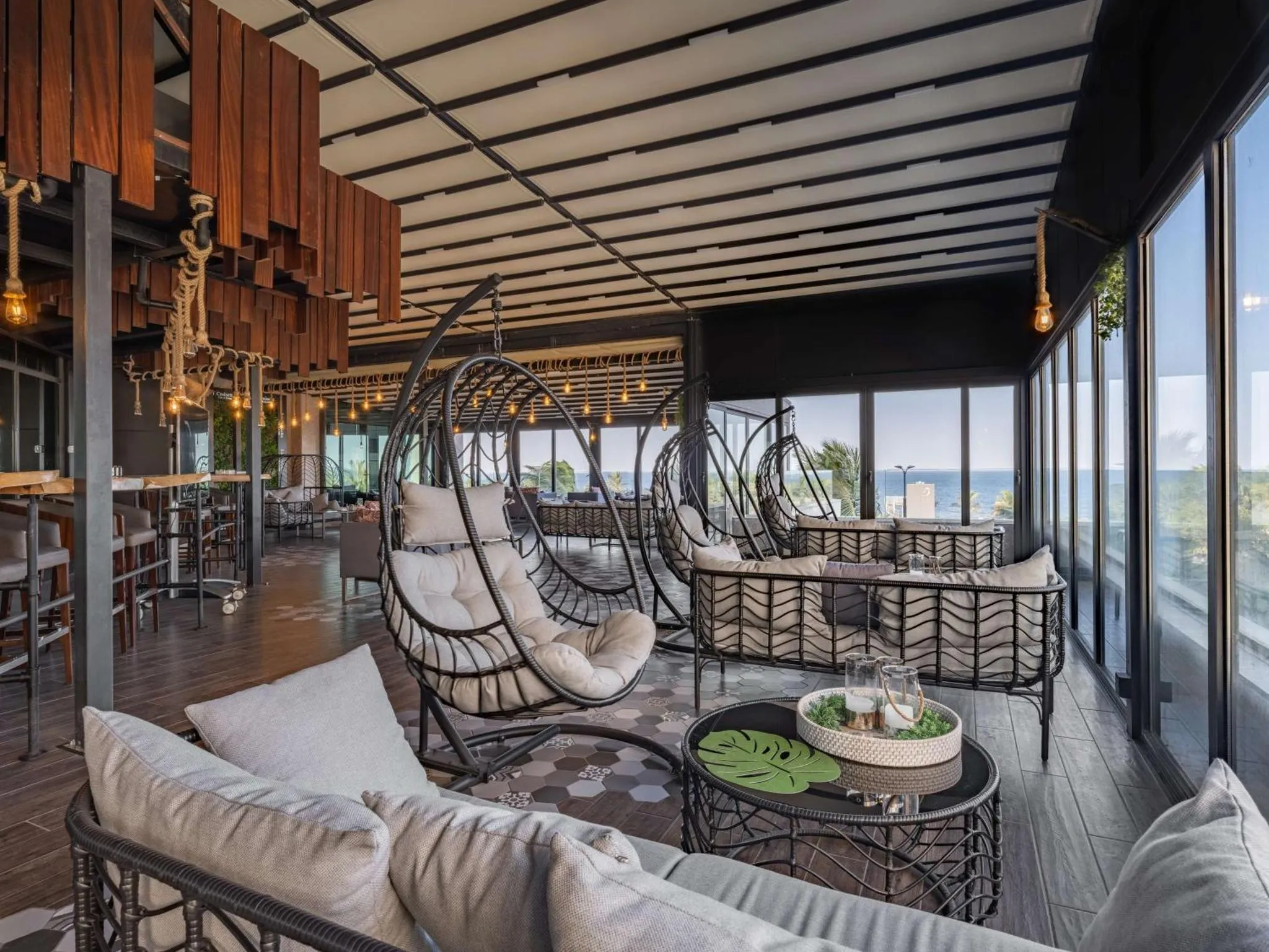 Espace de détente extérieur avec mobilier confortable et vue sur la mer.