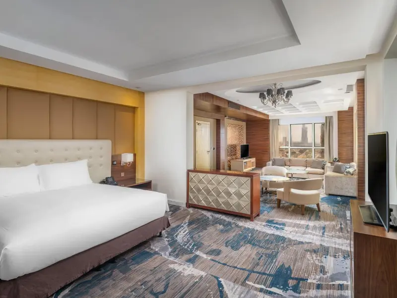 Une chambre spacieuse avec un grand lit et un coin salon.