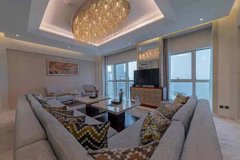 Un salon spacieux avec canapés et une grande fenêtre offrant une vue sur la mer.