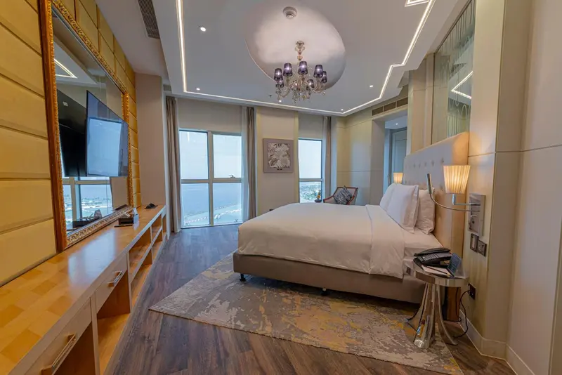 Chambre lumineuse avec un grand lit et une vue sur la mer.