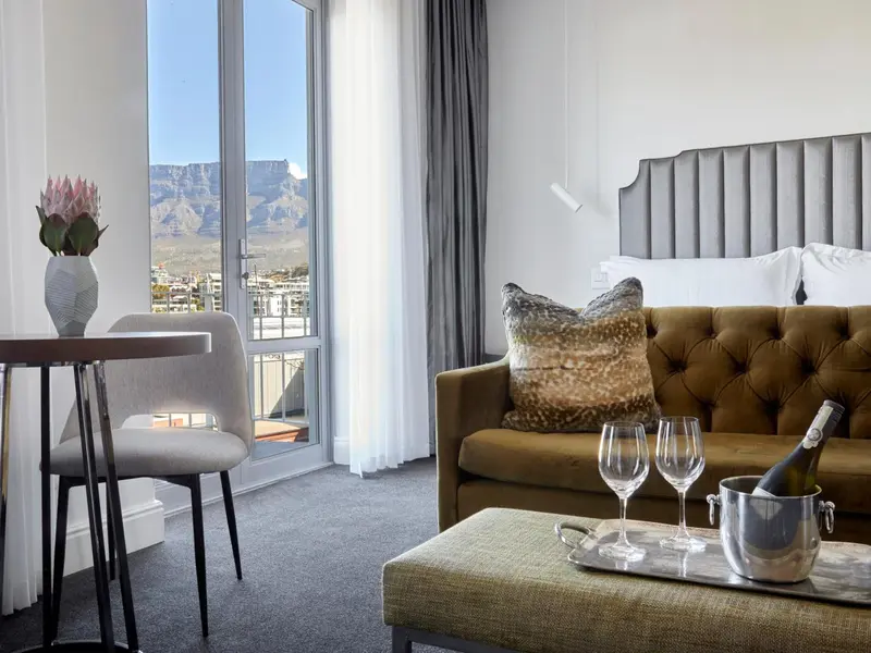 Une chambre avec un canapé et une table basse près d'une fenêtre offrant une vue sur la ville.