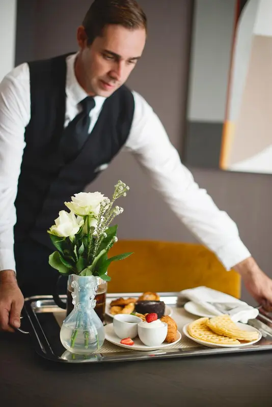 Un serveur apporte un plateau de petit-déjeuner à un client.