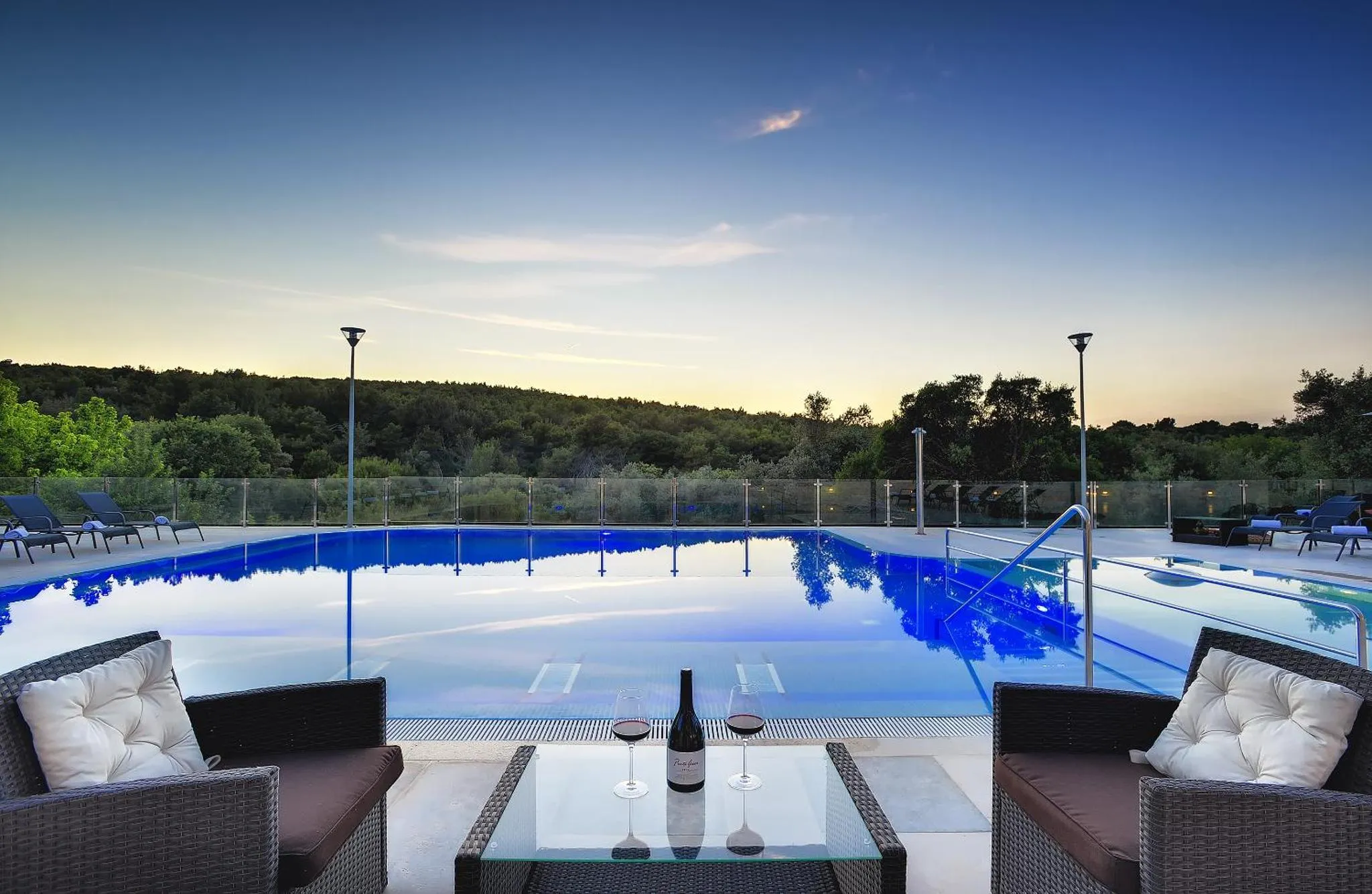 Terrasse avec salon et piscine au bord d'une vue sur la mer.